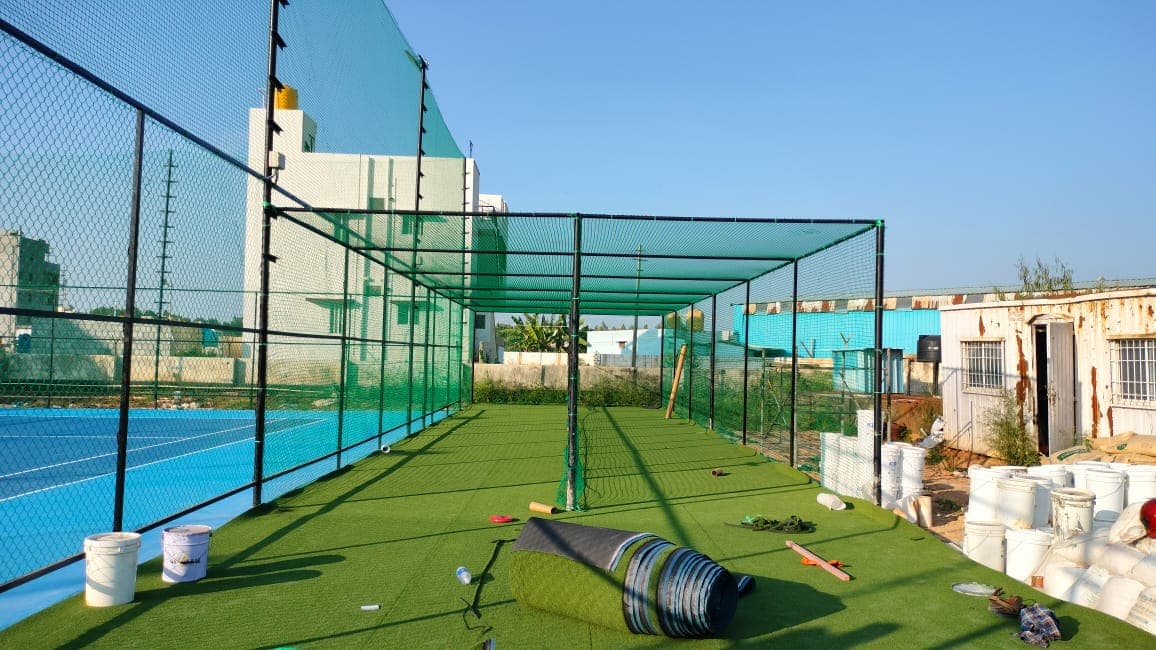 Professional heavy-gauge sports netting cage installed on terrace for residential housing society cricket practice pitch - AJ Safe Net Solutions