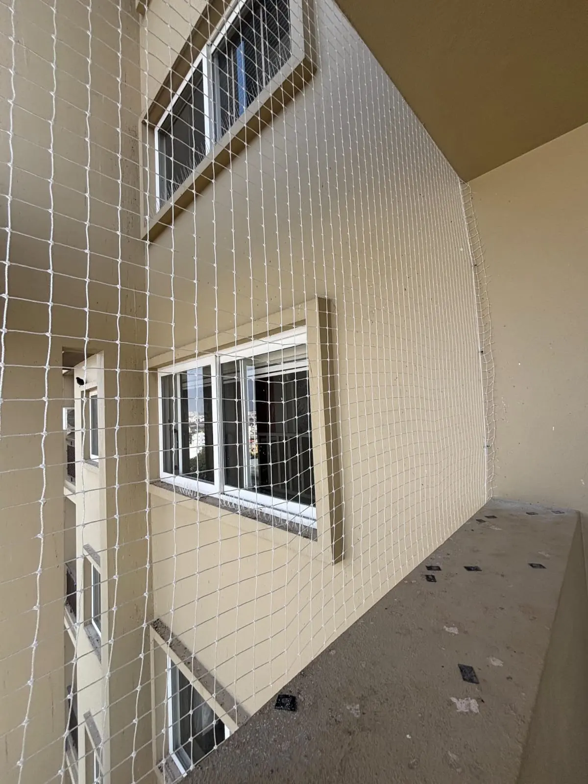 High-density transparent monofilament pigeon safety nets mounted tightly across window ducts - AJ Safe Net Solutions